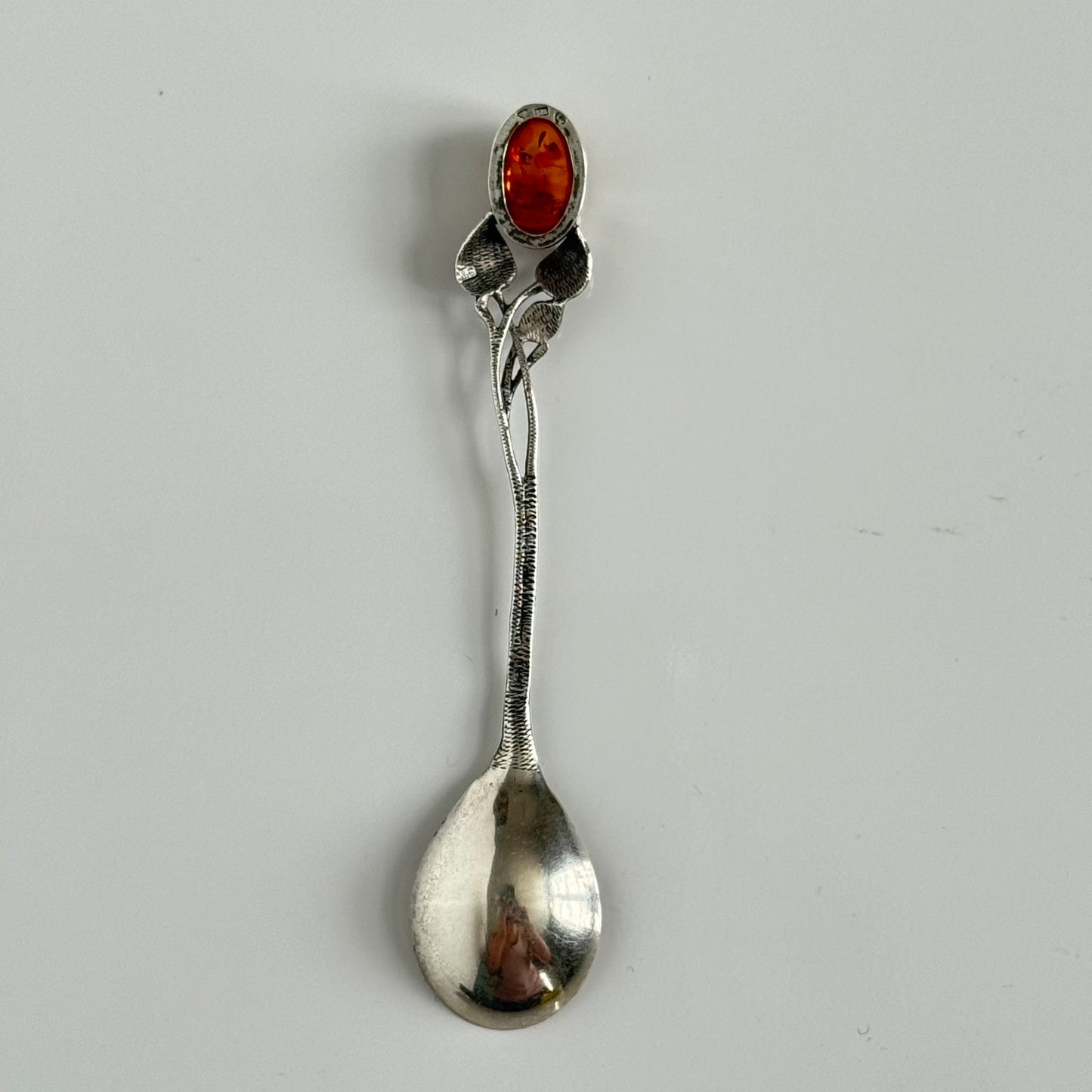 English: Art Nouveau style silver spoon with amber accent and delicate leaf motif, in 925 silver ; 日本語: アンバー(琥珀)付きアール・ヌーヴォー様式のシルバースプーン、繊細な葉モチーフと925シルバーの装飾 ; Français: Cuillère en argent style Art Nouveau avec ambre, décorée d’un motif feuillage délicat en argent 925.