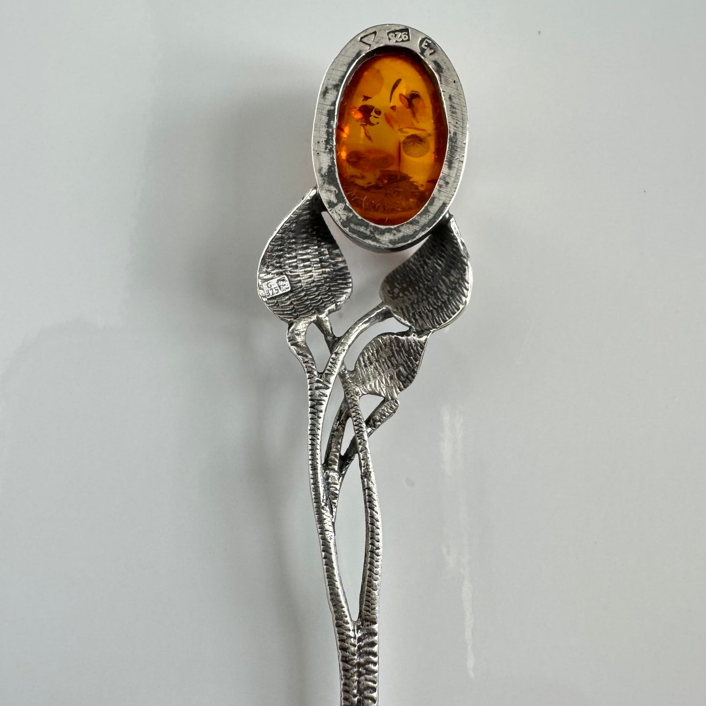 English: Art Nouveau style silver spoon with amber accent and delicate leaf motif, in 925 silver ; 日本語: アンバー(琥珀)付きアール・ヌーヴォー様式のシルバースプーン、繊細な葉モチーフと925シルバーの装飾 ; Français: Cuillère en argent style Art Nouveau avec ambre, décorée d’un motif feuillage délicat en argent 925.