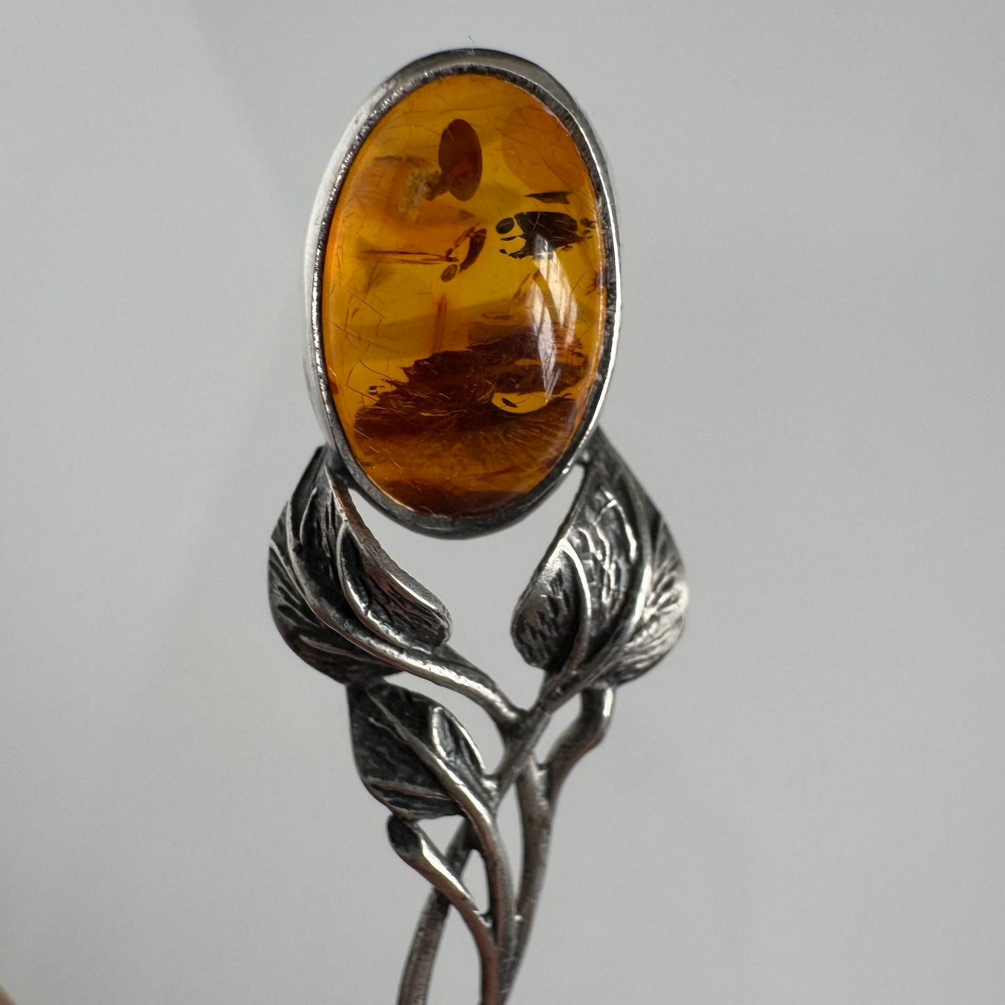 English: Art Nouveau style silver spoon with amber accent and delicate leaf motif, in 925 silver ; 日本語: アンバー(琥珀)付きアール・ヌーヴォー様式のシルバースプーン、繊細な葉モチーフと925シルバーの装飾 ; Français: Cuillère en argent style Art Nouveau avec ambre, décorée d’un motif feuillage délicat en argent 925.