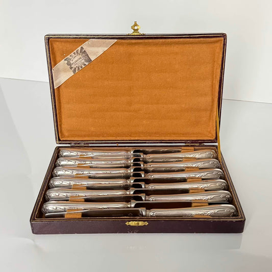 English: Set of six Christofle appetizer/dessert knives, Marly pattern, silver-plated handles, 20th century onward. Elegant French tableware with timeless botanical motifs. ; 日本語: クリストフル製の前菜/デザートナイフ6本セット、マルリーモデル、シルバープレートのハンドル、20世紀以降。洗練されたフランス製カトラリー、時代を超えた植物模様のデザイン。 ; Français: Ensemble de six couteaux à entremet Christofle, modèle Marly, manches en métal argenté, XXᵉ siècle. Élégant art de la table français aux motifs botaniques intemporels.