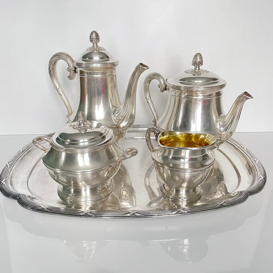 日本語: クリストフル「Rubans」モデルのシルバープレート製ティー&コーヒーセット。リボンモチーフが特徴。トレイ、シュガーボウル、ミルクジャグ、コーヒーポット、ティーポットの5点セット。; English: Christofle "Rubans" silver-plated tea & coffee set. Featuring a ribbon motif. Includes tray, sugar bowl, milk jug, coffee pot, and teapot. ; Français: Service à thé et café en métal argenté Christofle, modèle Rubans, avec motif de rubans. Comprend un plateau, un sucrier, un pot à lait, une cafetière et une théière.