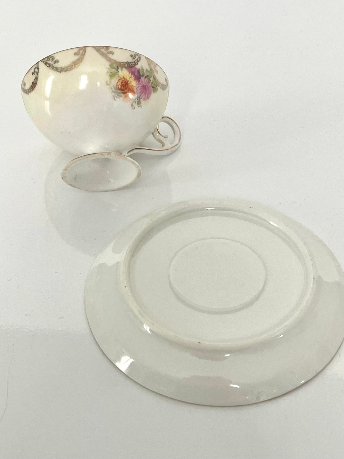 日本語: 優雅な新古典主義のカップ&ソーサーセット。ピンクと白の背景に精緻な新古典主義なモチーフと花柄が施されてます。金色のアクセントが豪華さを増しています。; English: Elegant cup and saucer set featuring a pink and white background with intricate neoclassical and floral motifs, complemented by golden accents for a regal and luxurious charm. ; Français: Ensemble élégant de tasse et soucoupe avec un fond rose et blanc, décoré de motifs néoclassiques et floraux, rehaussé d'accents dorés pour un charme luxueux.