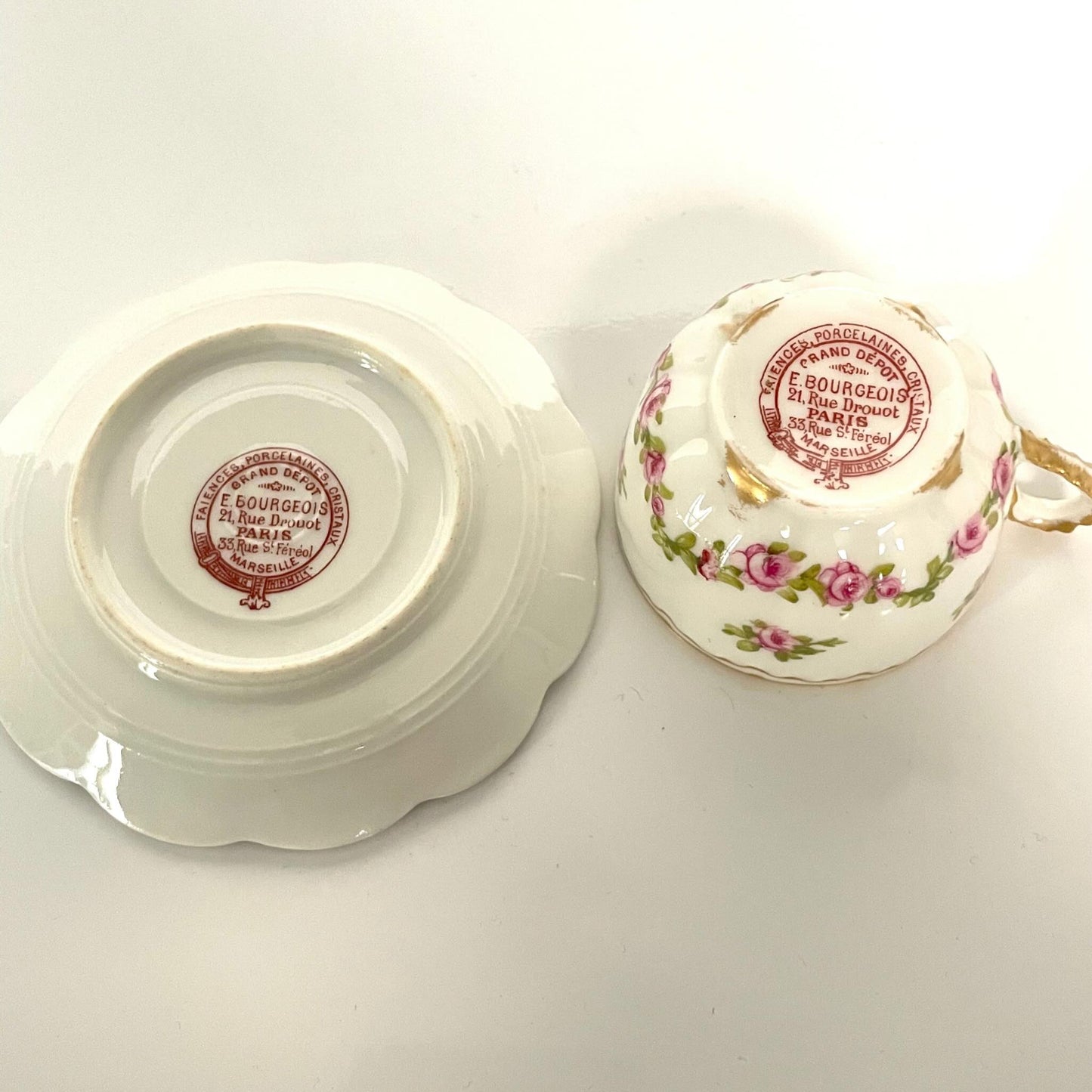 日本語: 優美なバラのガーランド模様のカップ&ソーサーセット。繊細な花柄が特徴で、裏面に「Grand Dépôt E. Bourgeois」の刻印あり。19世紀後期から20世紀初頭に製作された品。; English: Elegant cup and saucer set featuring a delicate garland of roses. Marked with "Grand Dépôt E. Bourgeois" on the underside. Produced in the late 19th to early 20th century. ; Français: Élégant ensemble tasse et soucoupe avec guirlande de roses délicate. Marqué "Grand Dépôt E. Bourgeois" au dos. Fabriqué entre la fin du 19ᵉ et le début du 20ᵉ siècle.