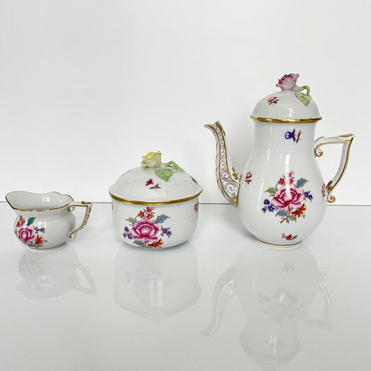 日本語: ハンガリーのヘレンド製「南京ブーケ」シリーズのティーポット、シュガーボウル、クリーマーの3点セット。繊細な花柄が特徴のシノワズリスタイル。; English: Herend "Nanjing Bouquet" 3-piece set, featuring a teapot, sugar bowl, and creamer with delicate floral motifs in a Chinoiserie style. ; Français: Ensemble de 3 pièces "Nanjing Bouquet" de Herend, comprenant une théière, un sucre et un pot à lait avec des motifs floraux délicats dans un style chinoiserie.