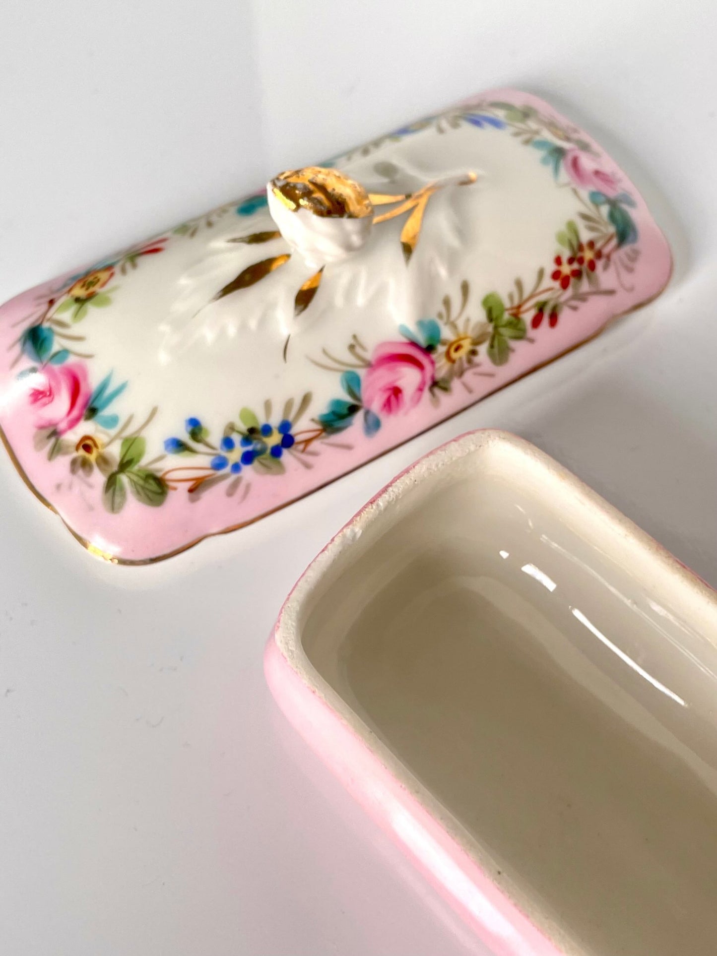 日本語: オールドパリ製の手描きバラと花が描かれた小さなトリンケットボックス(小物入れ)。ピンクのベース色が優しい印象を与え、ソープディッシュとして使われた可能性があります。; English: Old Paris small trinket box featuring hand-painted roses and flowers on a soft pink base, likely used as a soap dish. A charming addition to any bathroom or vanity. ; Français: Petite boîte Vieux Paris avec des roses et des fleurs peintes à la main sur une base rose douce, probablement utilisée comme porte-savon. Un ajout charmant pour toute salle de bain ou coiffeuse.