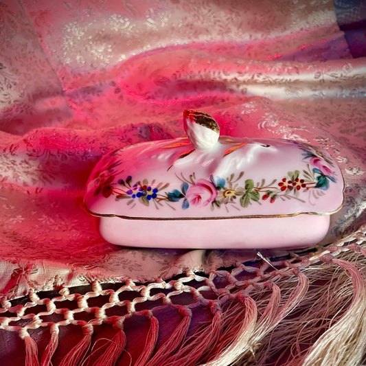 日本語: オールドパリ製の手描きバラと花が描かれた小さなトリンケットボックス(小物入れ)。ピンクのベース色が優しい印象を与え、ソープディッシュとして使われた可能性があります。; English: Old Paris small trinket box featuring hand-painted roses and flowers on a soft pink base, likely used as a soap dish. A charming addition to any bathroom or vanity. ; Français: Petite boîte Vieux Paris avec des roses et des fleurs peintes à la main sur une base rose douce, probablement utilisée comme porte-savon. Un ajout charmant pour toute salle de bain ou coiffeuse.