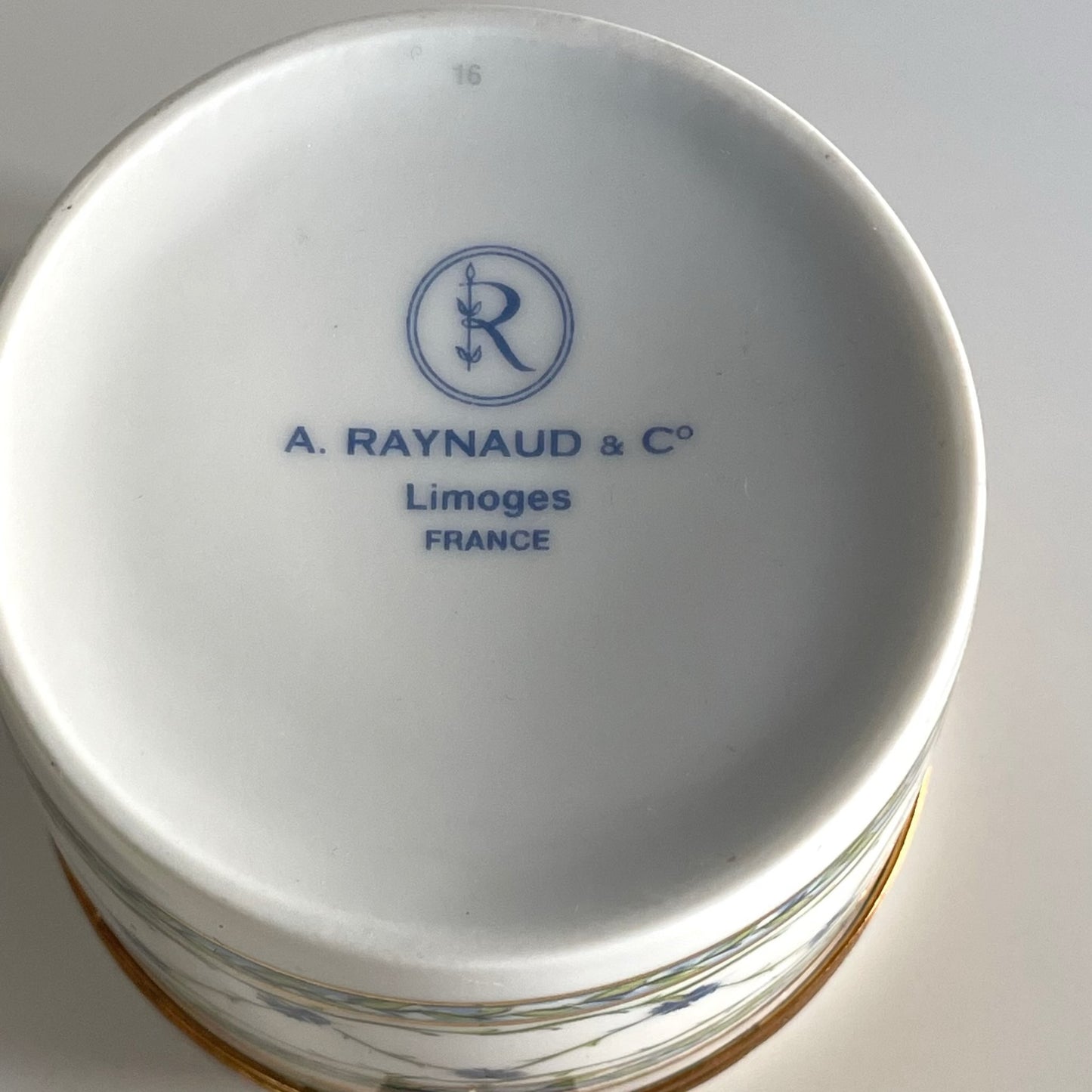 日本語: レイノー製のトリンケットボックス(小物入れ)、18世紀フランス貴族に人気の矢車菊模様と金のギルディングが施され、優雅さとラグジュアリーを引き立てます。; English: Raynaud trinket box with a cornflower motif and gold gilding, inspired by 18th-century French aristocracy. A simple yet luxurious design with sophisticated charm. ; Français: Boîte Raynaud avec motif de barbeaux et dorure, inspirée de l'aristocratie française du XVIIIe siècle. Un design simple mais luxueux et charmant.