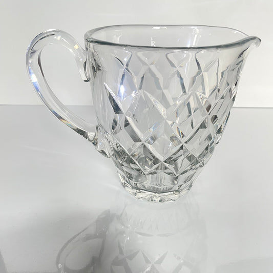 日本語: サンルイ製クリスタル水差し「アドゥール」モデル。ダイヤモンドカットの模様が光を美しく反射し、テーブルに素晴らしい輝きを与えます。; English: Saint-Louis Adour crystal water jug with a diamond-cut pattern that refracts light beautifully, creating stunning reflections. ; Français: broc à eau en cristal Saint-Louis modèle Adour avec motif taillé en diamant, réfractant la lumière de manière magnifique et créant de superbes reflets.