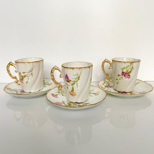 English: Set of three porcelain cups and saucers with elegant floral décor, late 19th – early 20th century. Delicate antique craftsmanship. ; 日本語: 19世紀後期から20世紀初期の磁器製カップ&ソーサー3客セット。上品な花柄装飾と繊細なアンティークの技術。 ; Français: Ensemble de trois tasses et sous-tasses en porcelaine avec décor floral élégant, fin 19ᵉ – début 20ᵉ siècle. Raffinement et savoir-faire ancien.