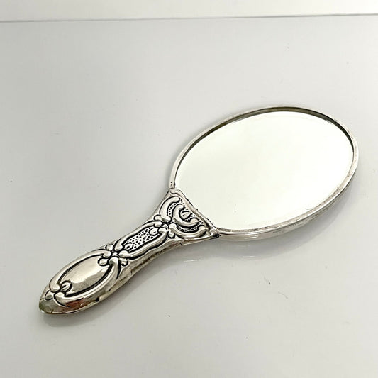 日本語: シルバー製ハンドミラー、ローズモチーフ、手彫りの精緻なデザイン。コンパクトで、バッグにもぴったり。 ; English: Silver hand mirror with intricate rose motifs, hand-etched design. Compact size, perfect for a handbag. ; Français: Miroir à main en argent avec des motifs de roses délicats, conception gravée à la main. Taille compacte, parfait pour un sac à main.