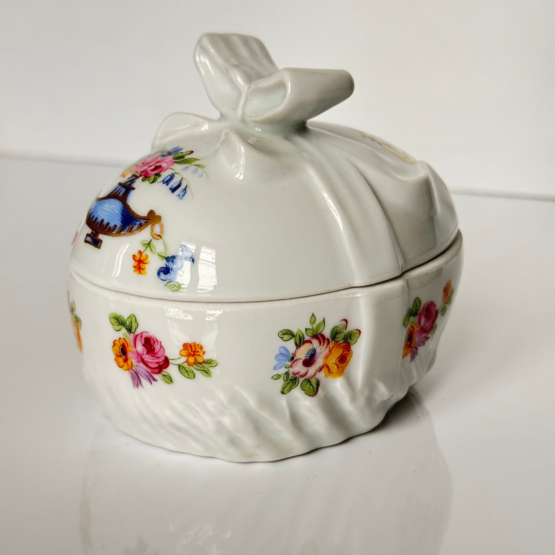 Vintage porcelain egg-shaped box by APILCO, inspired by the 18th-century Sèvres du Barry service. Features ribbon details, floral patterns, and “DB” initials in elegant design