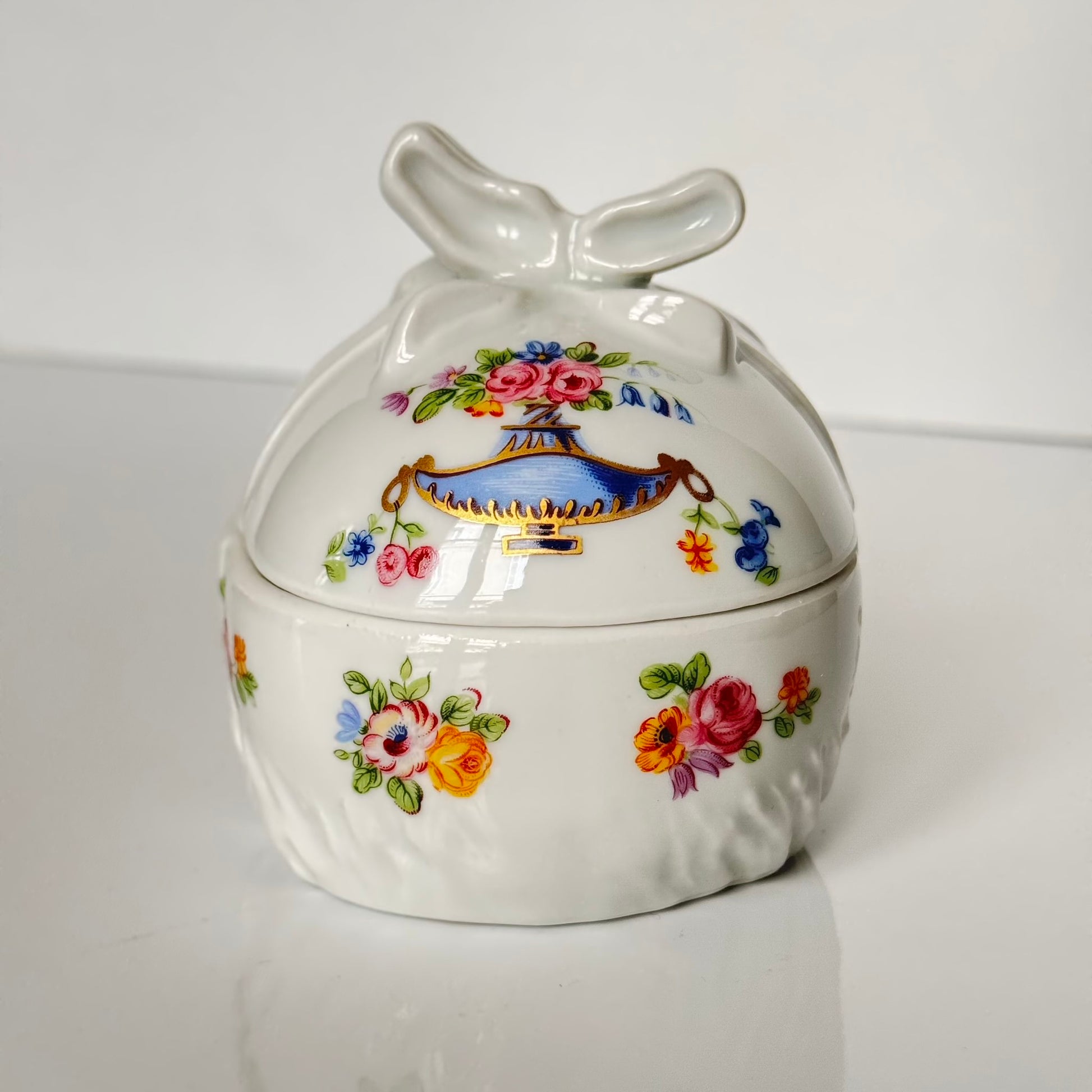 Vintage porcelain egg-shaped box by APILCO, inspired by the 18th-century Sèvres du Barry service. Features ribbon details, floral patterns, and “DB” initials in elegant design