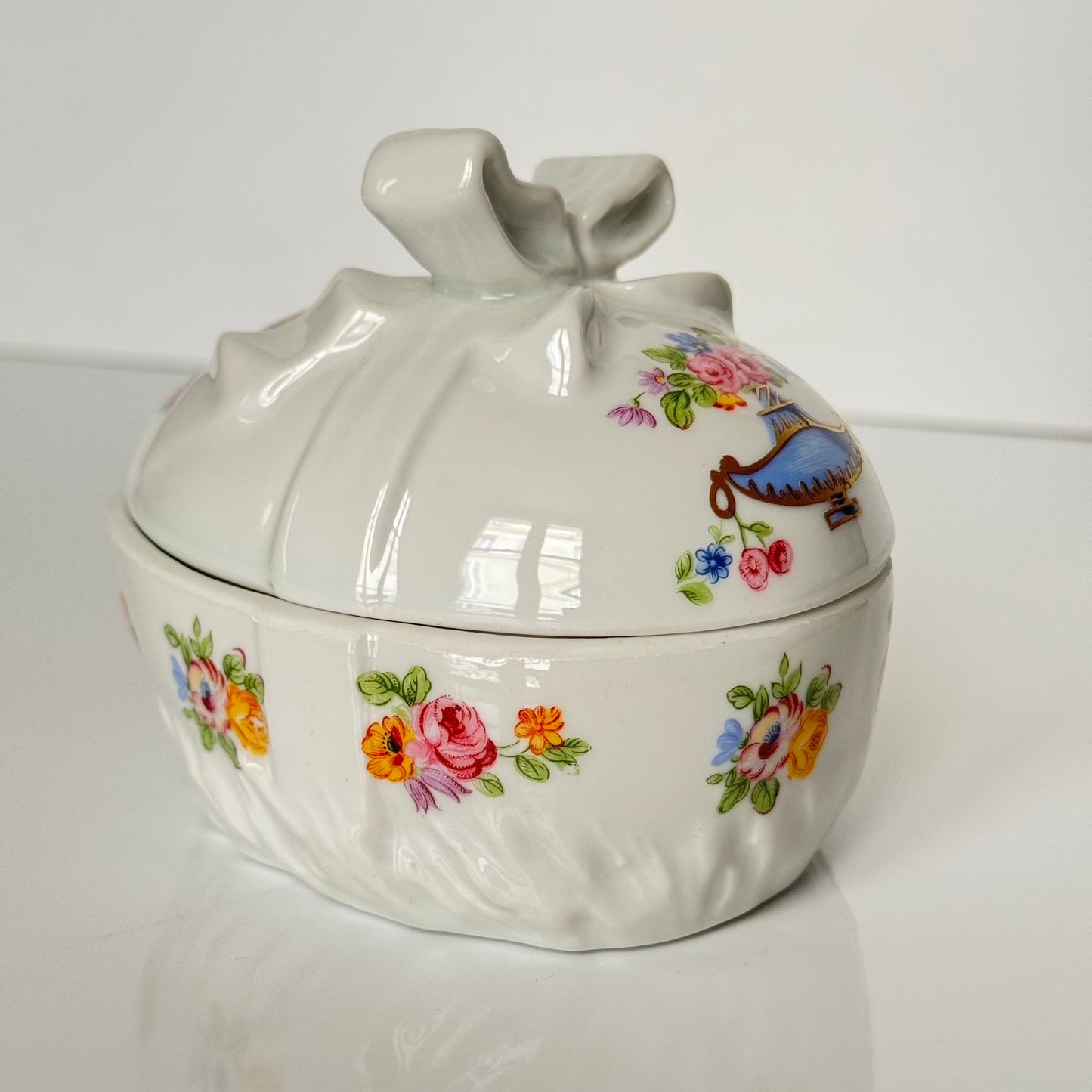 Vintage porcelain egg-shaped box by APILCO, inspired by the 18th-century Sèvres du Barry service. Features ribbon details, floral patterns, and “DB” initials in elegant design