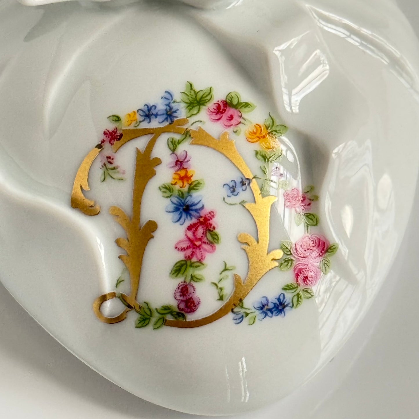 Vintage porcelain egg-shaped box by APILCO, inspired by the 18th-century Sèvres du Barry service. Features ribbon details, floral patterns, and “DB” initials in elegant design