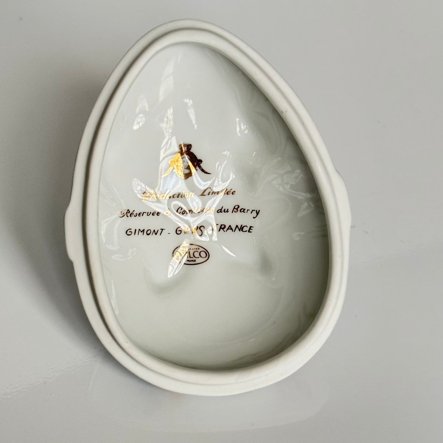 Vintage porcelain egg-shaped box by APILCO, inspired by the 18th-century Sèvres du Barry service. Features ribbon details, floral patterns, and “DB” initials in elegant design