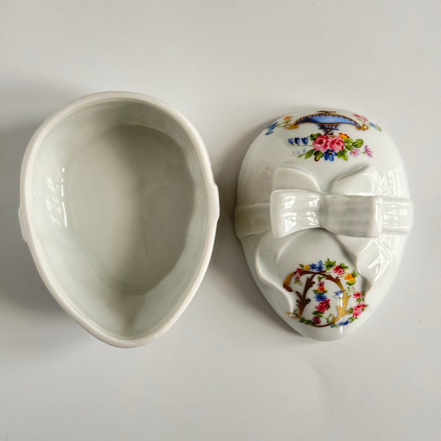 Vintage porcelain egg-shaped box by APILCO, inspired by the 18th-century Sèvres du Barry service. Features ribbon details, floral patterns, and “DB” initials in elegant design