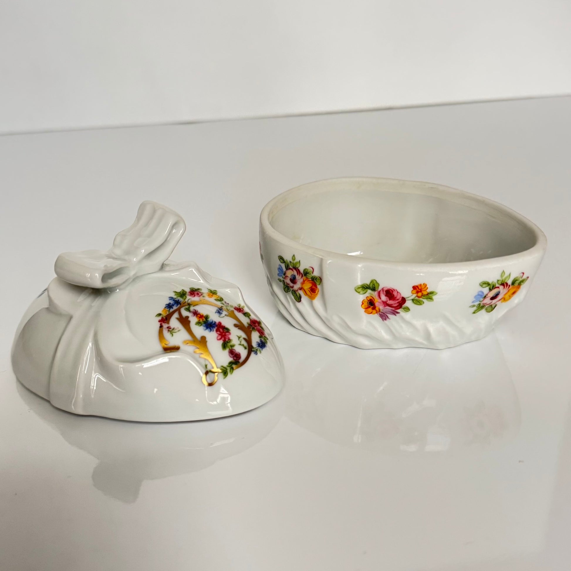 Vintage porcelain egg-shaped box by APILCO, inspired by the 18th-century Sèvres du Barry service. Features ribbon details, floral patterns, and “DB” initials in elegant design