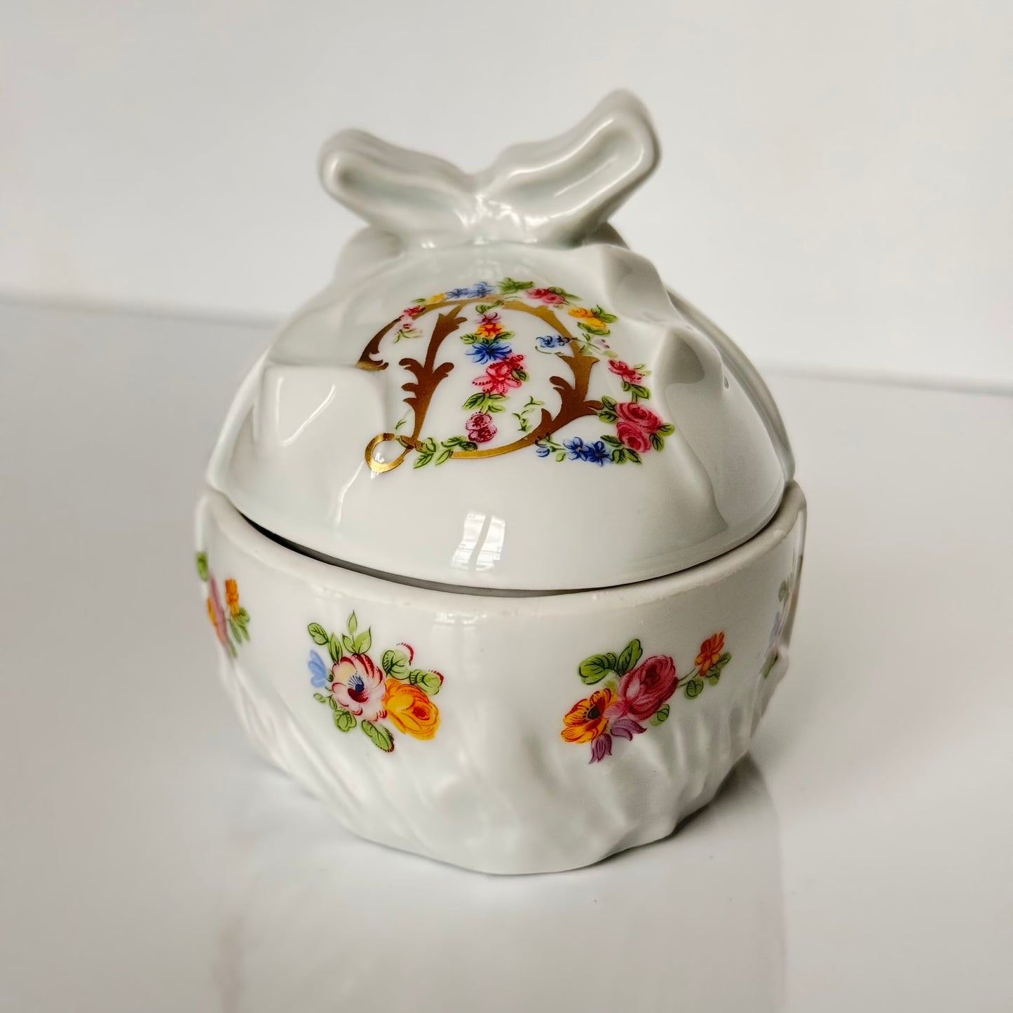 Vintage porcelain egg-shaped box by APILCO, inspired by the 18th-century Sèvres du Barry service. Features ribbon details, floral patterns, and “DB” initials in elegant design