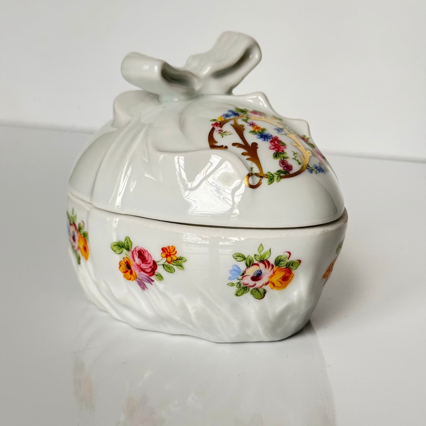 Vintage porcelain egg-shaped box by APILCO, inspired by the 18th-century Sèvres du Barry service. Features ribbon details, floral patterns, and “DB” initials in elegant design