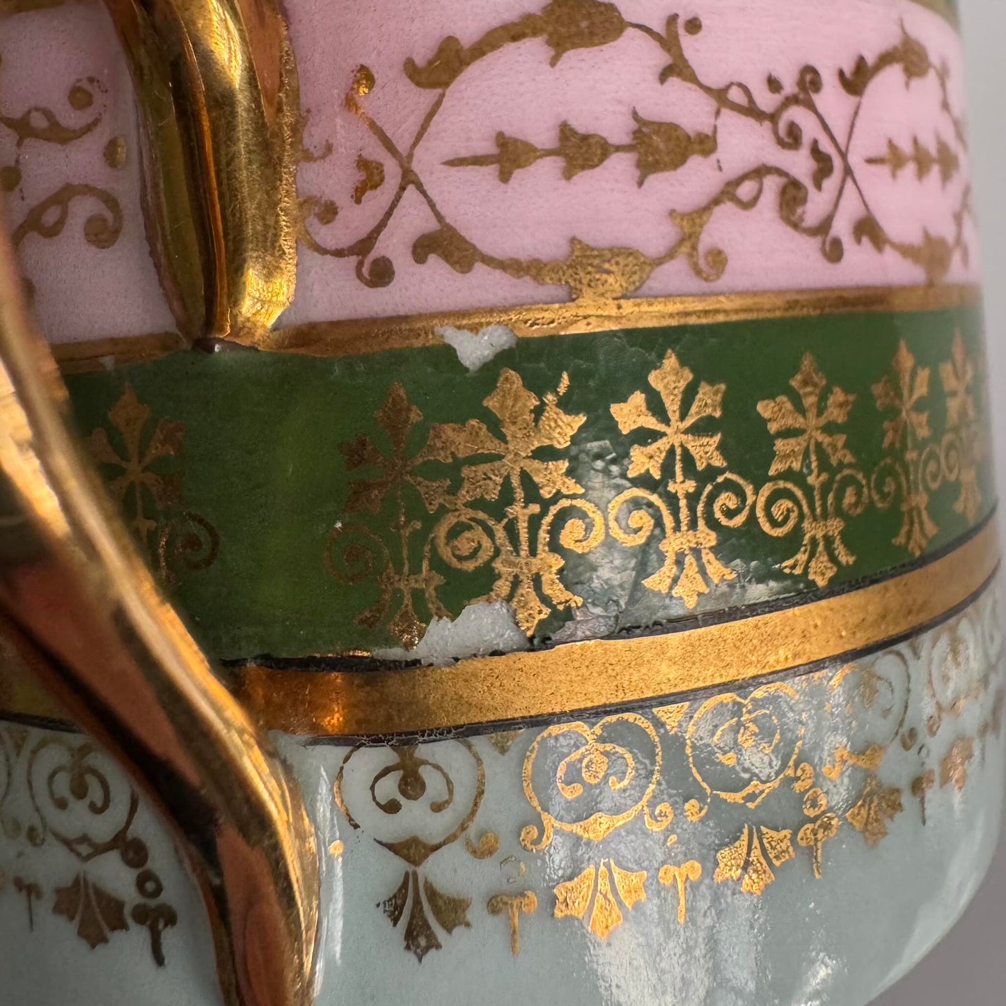 Porcelain cup and saucer set inspired by 18th-century Sèvres style, with delicate pink and green hues and gilded details.