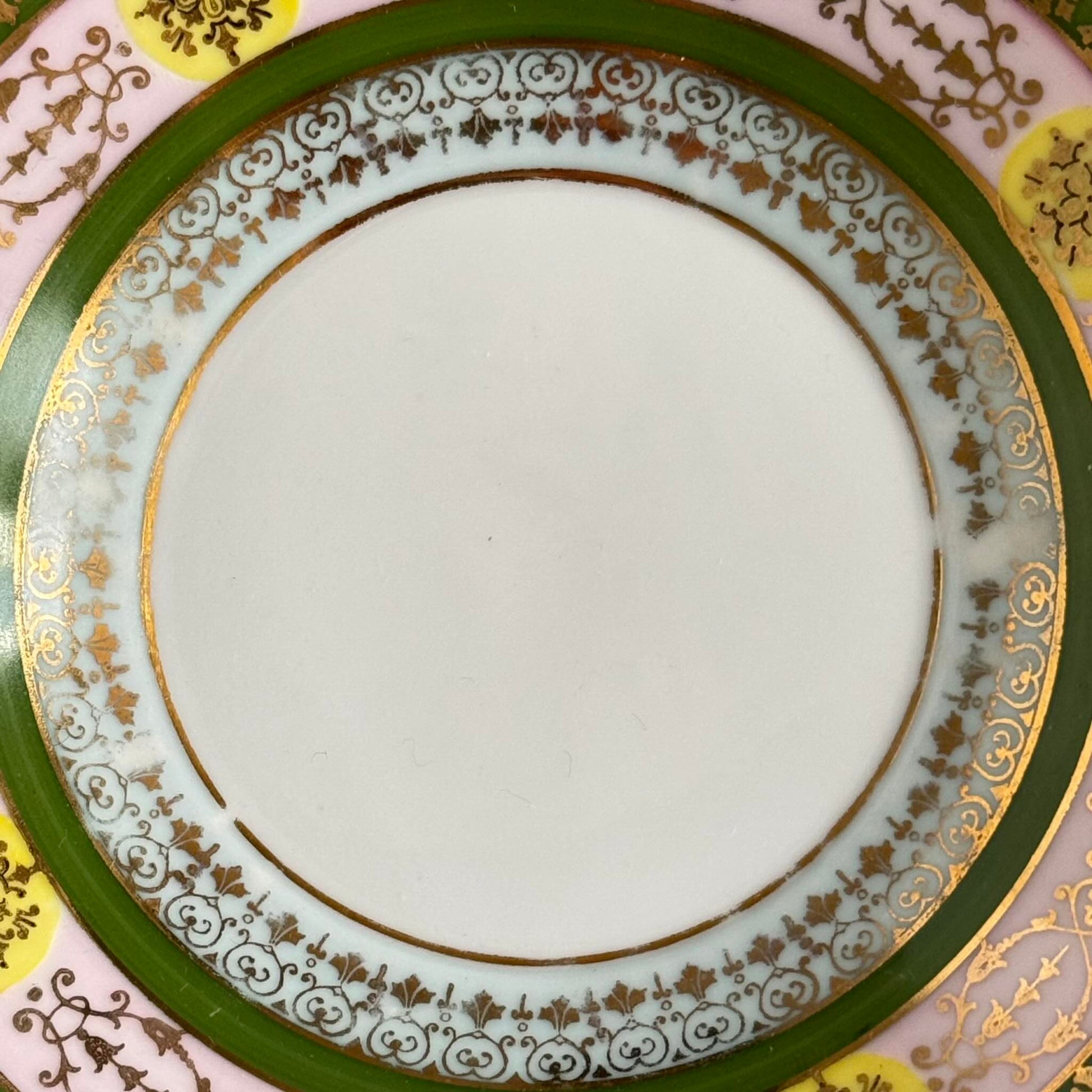 Porcelain cup and saucer set inspired by 18th-century Sèvres style, with delicate pink and green hues and gilded details.