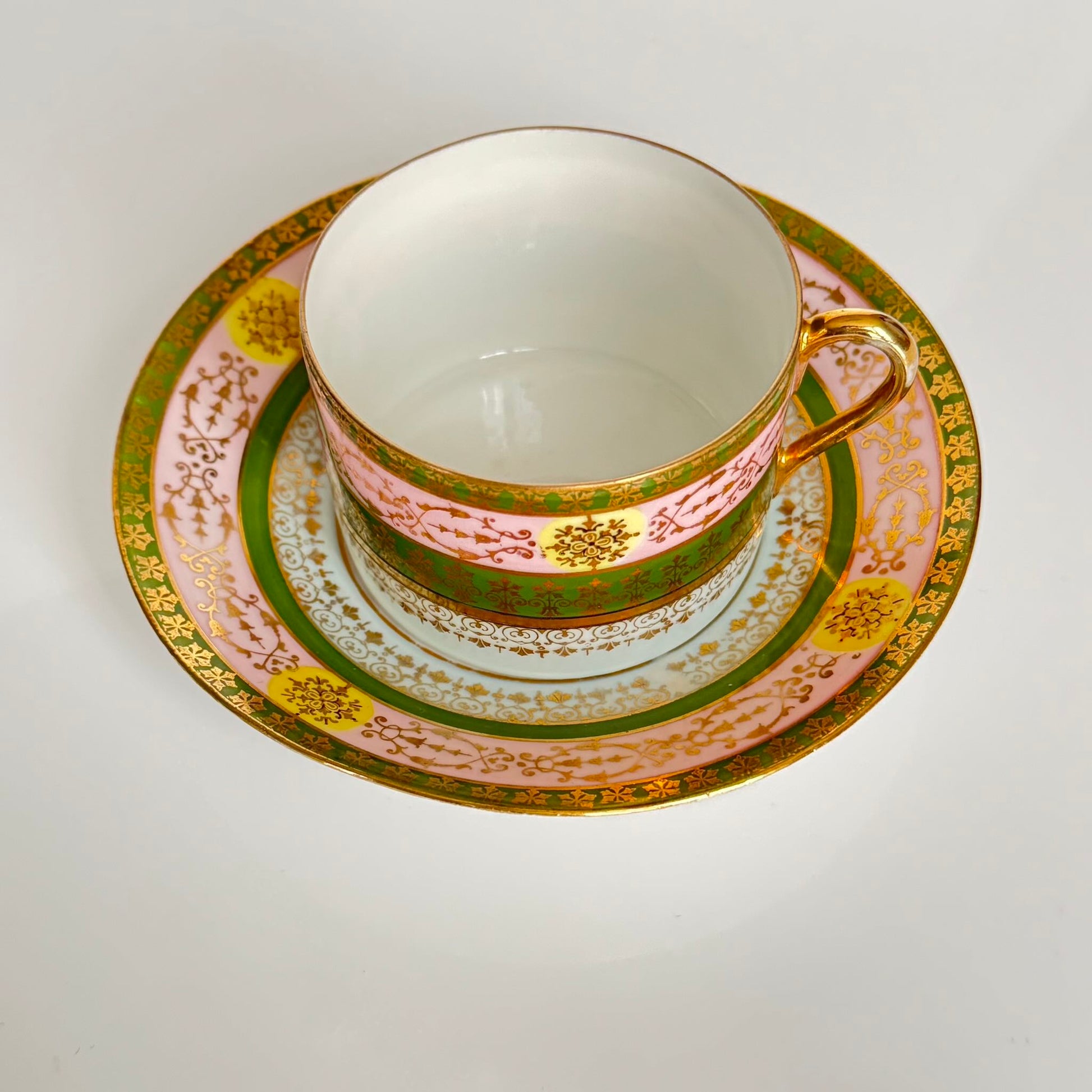 Porcelain cup and saucer set inspired by 18th-century Sèvres style, with delicate pink and green hues and gilded details.