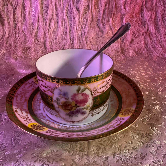 Porcelain cup and saucer set inspired by 18th-century Sèvres style, with delicate pink and green hues and gilded details.