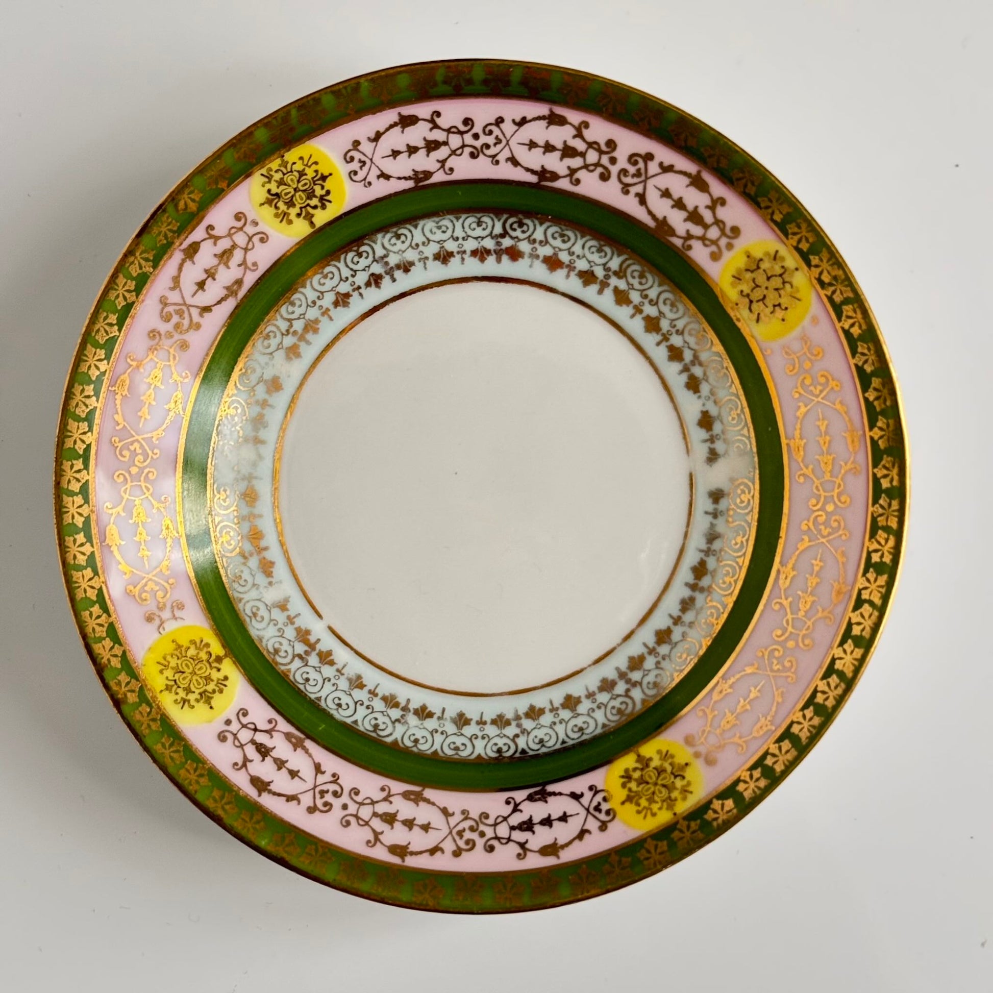 Porcelain cup and saucer set inspired by 18th-century Sèvres style, with delicate pink and green hues and gilded details.