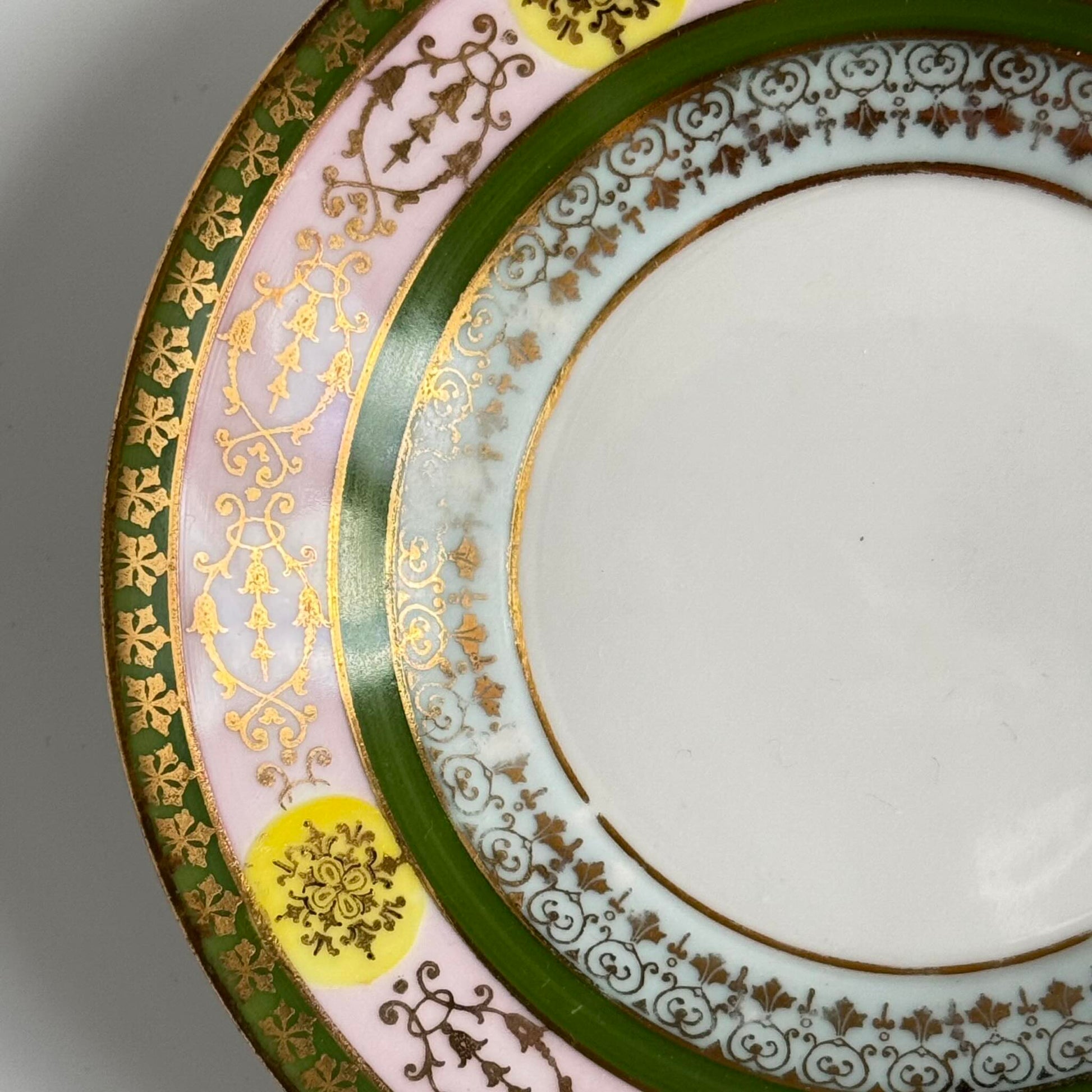Porcelain cup and saucer set inspired by 18th-century Sèvres style, with delicate pink and green hues and gilded details.