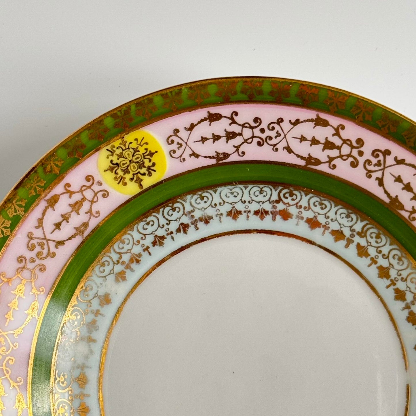 Porcelain cup and saucer set inspired by 18th-century Sèvres style, with delicate pink and green hues and gilded details.