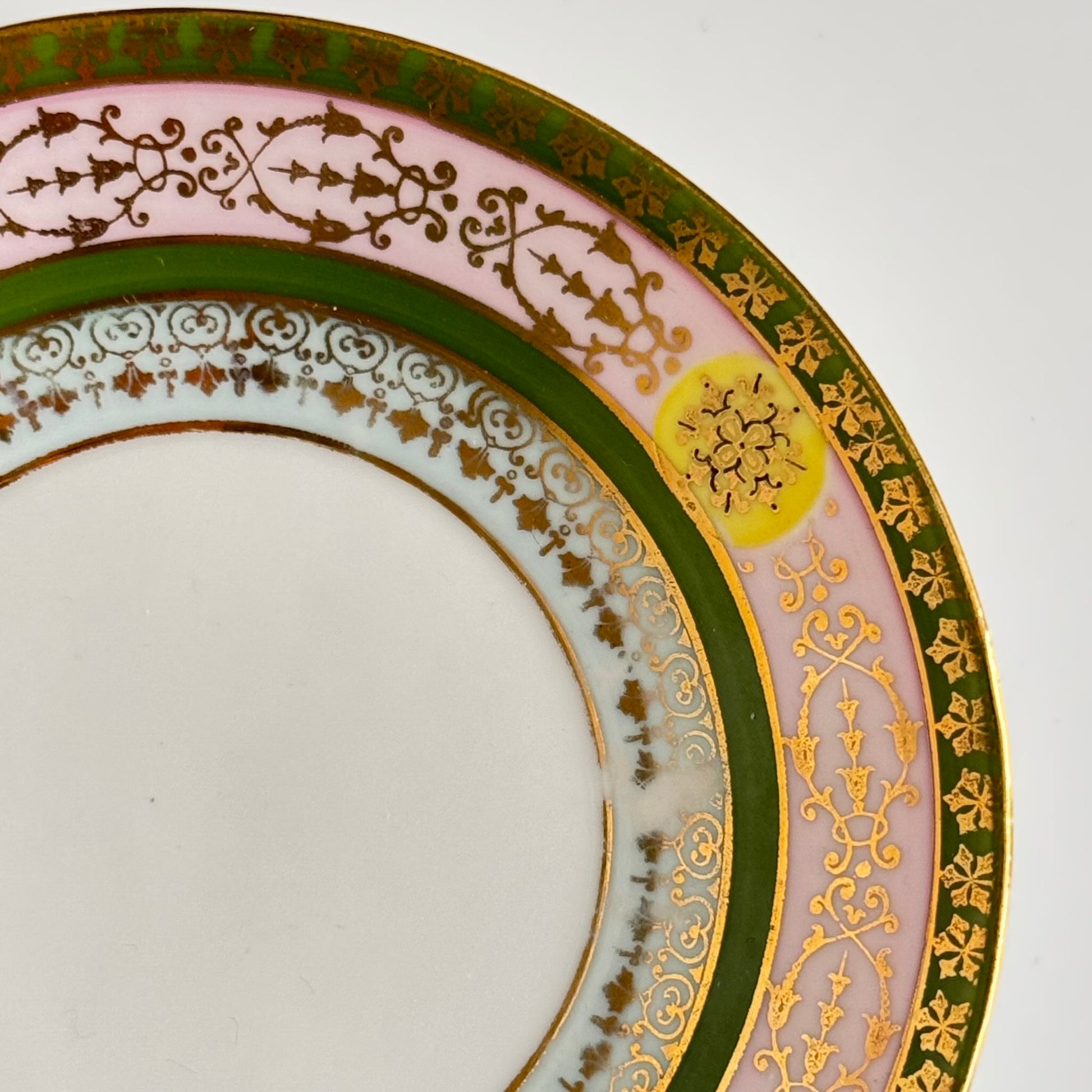 Porcelain cup and saucer set inspired by 18th-century Sèvres style, with delicate pink and green hues and gilded details.