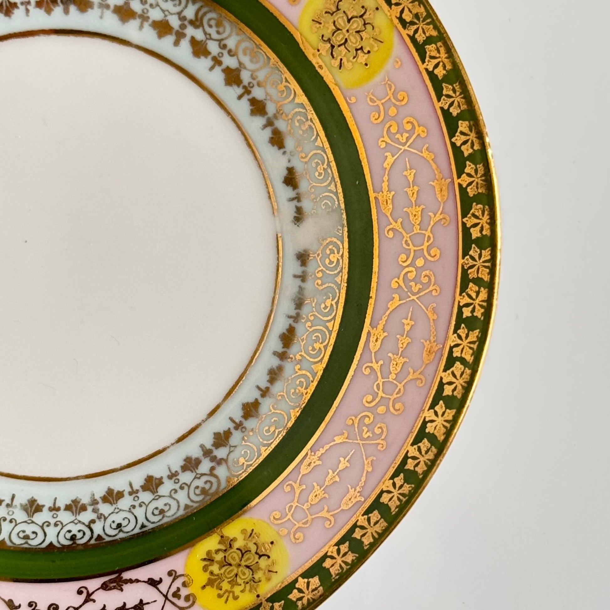 Porcelain cup and saucer set inspired by 18th-century Sèvres style, with delicate pink and green hues and gilded details.