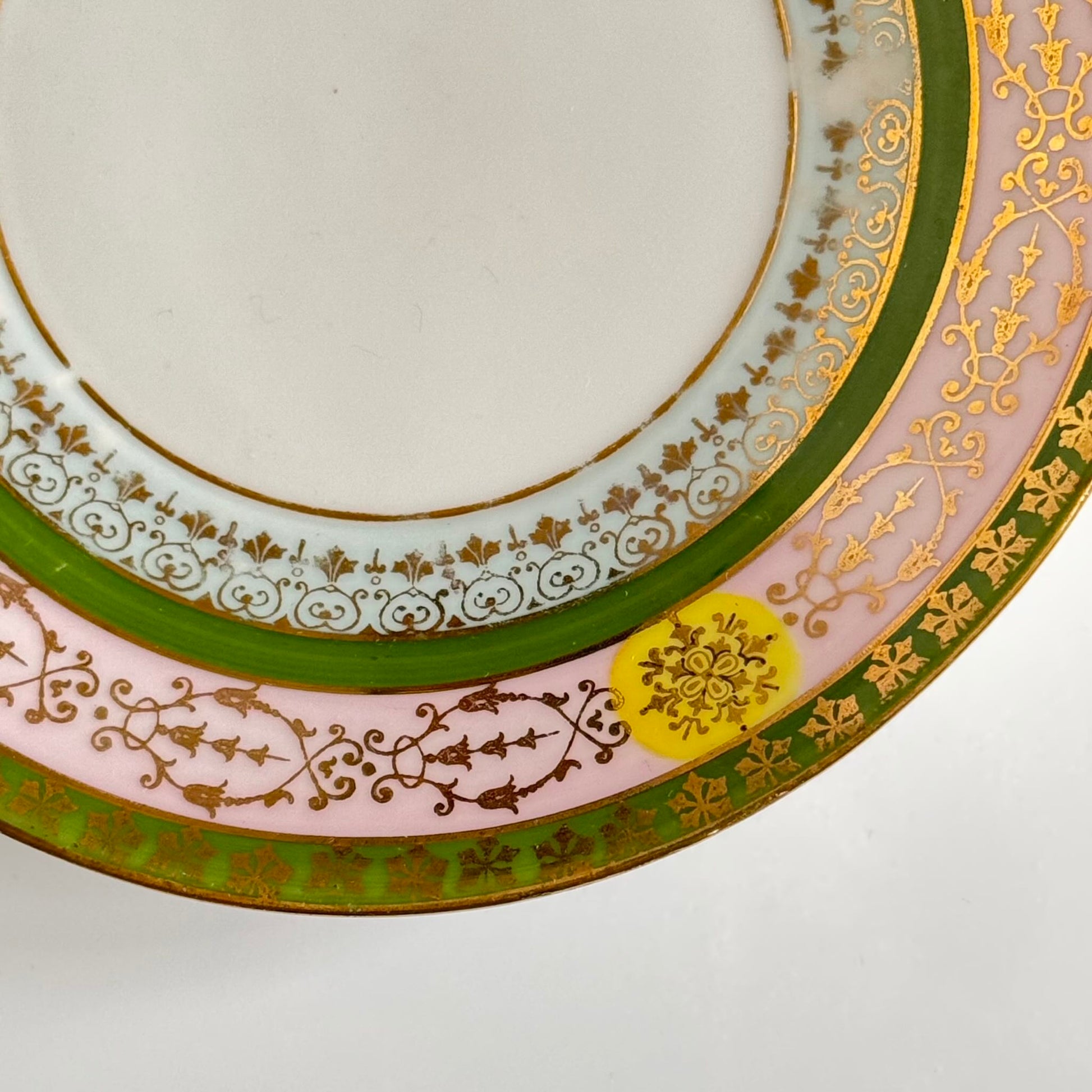 Porcelain cup and saucer set inspired by 18th-century Sèvres style, with delicate pink and green hues and gilded details.