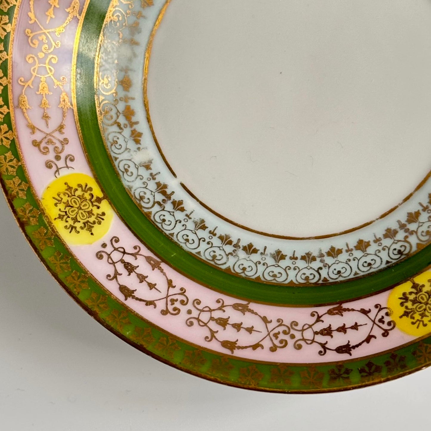 Porcelain cup and saucer set inspired by 18th-century Sèvres style, with delicate pink and green hues and gilded details.