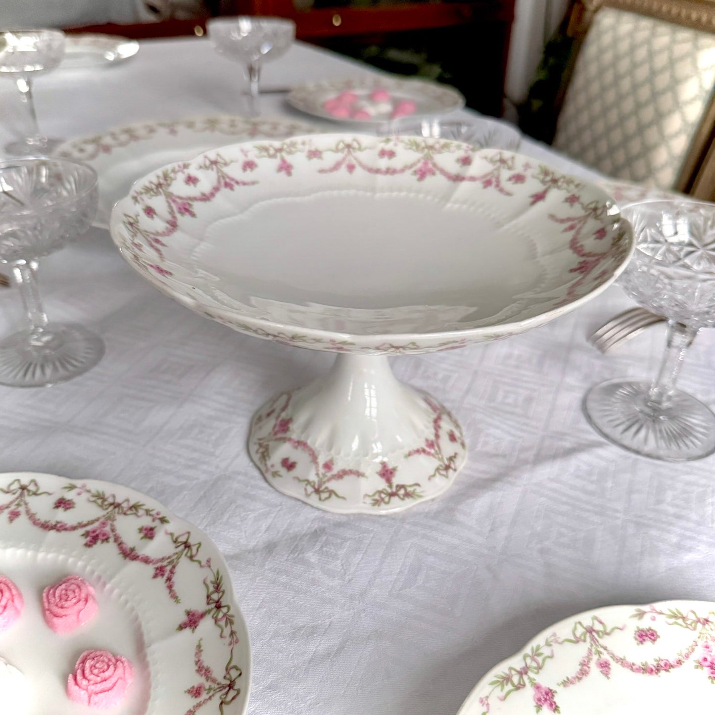 English: Ahrenfeldt Limoges porcelain compote on pedestal with ribbon and floral garland decoration, late 19th to early 20th century, France. ;
Français : Compotier en porcelaine de Limoges Ahrenfeldt sur piédouche, décor de rubans et guirlandes de fleurs, fin XIXᵉ – début XXᵉ siècle. ;
日本語: アーレンフェルト製 リモージュ磁器の脚付きコンポティエ（フルーツスタンド）。リボンとガーランドの装飾、19世紀末〜20世紀初頭 フランス。