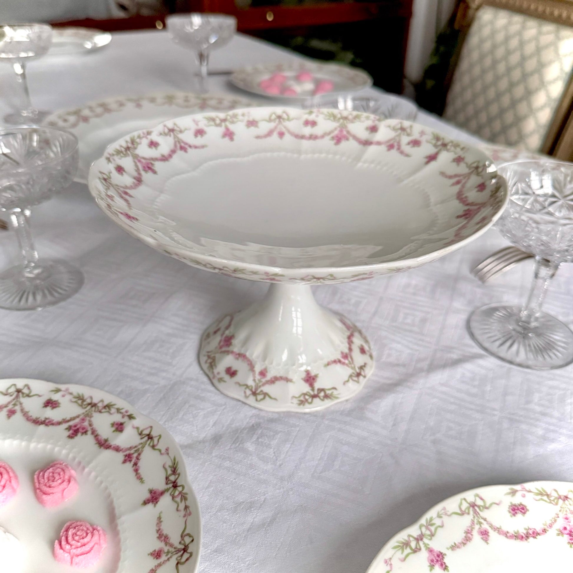 English: Ahrenfeldt Limoges porcelain compote on pedestal with ribbon and floral garland decoration, late 19th to early 20th century, France. ;
Français : Compotier en porcelaine de Limoges Ahrenfeldt sur piédouche, décor de rubans et guirlandes de fleurs, fin XIXᵉ – début XXᵉ siècle. ;
日本語: アーレンフェルト製 リモージュ磁器の脚付きコンポティエ（フルーツスタンド）。リボンとガーランドの装飾、19世紀末〜20世紀初頭 フランス。