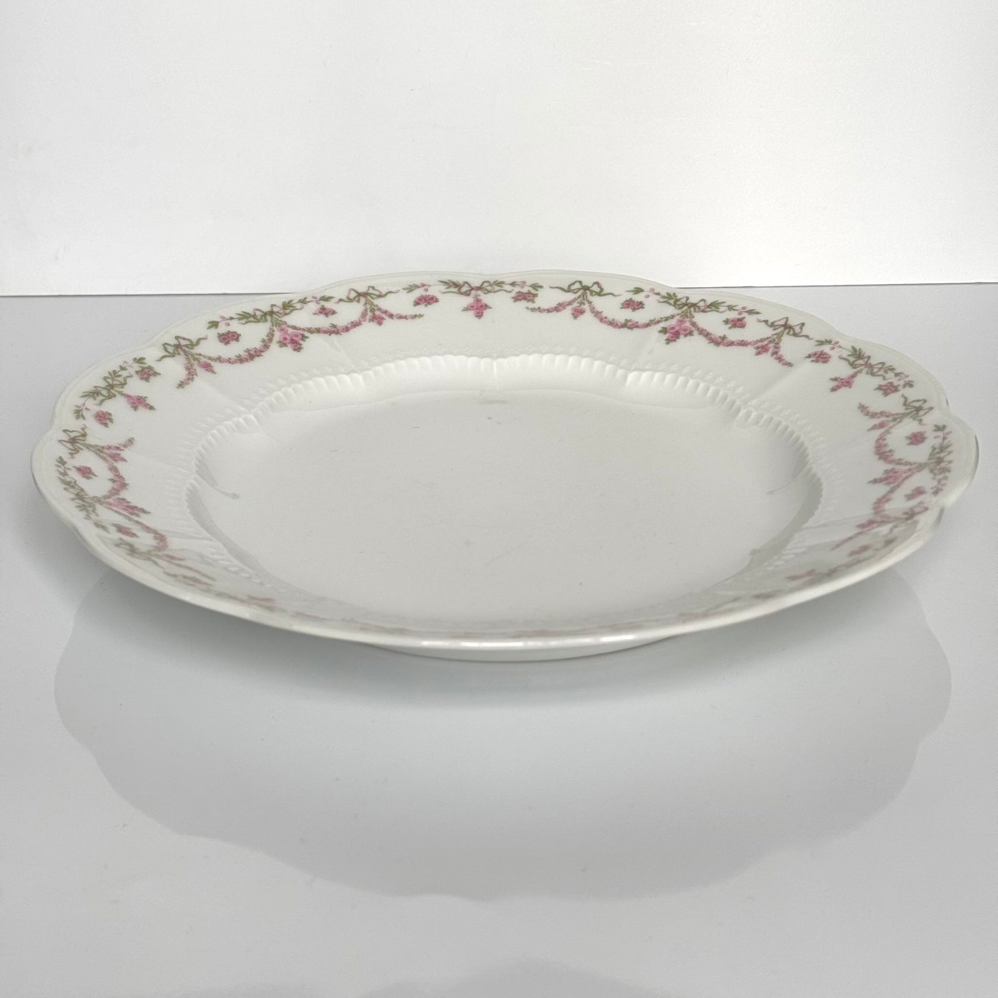 English: Ahrenfeldt Limoges porcelain serving platter with ribbon and floral garland decoration, late 19th–early 20th century ; Français : Plat de service en porcelaine Limoges Ahrenfeldt avec décor de rubans et guirlandes florales, fin XIXᵉ – début XXᵉ siècle ; 日本語: リモージュ Ahrenfeldt 製 ポーセリン大型プレート（リボンと花のガーランド装飾）、19世紀末〜20世紀初頭。