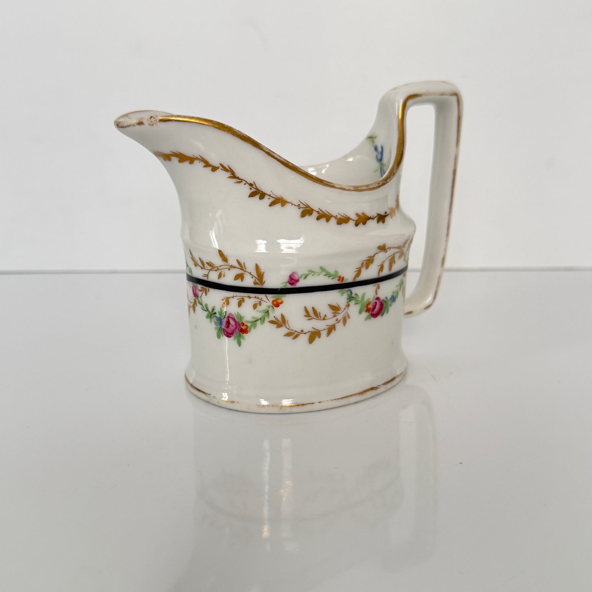 Antique Clignancourt hard-paste porcelain milk jug, hand-painted floral garlands, 18th century France.