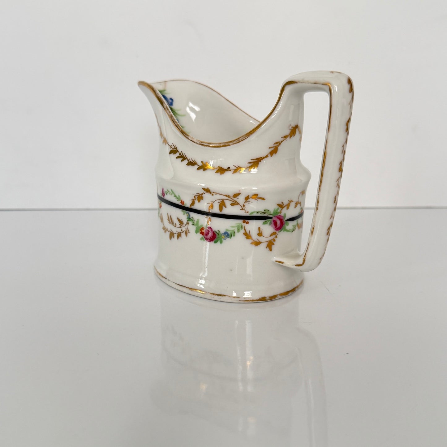 Antique Clignancourt hard-paste porcelain milk jug, hand-painted floral garlands, 18th century France.