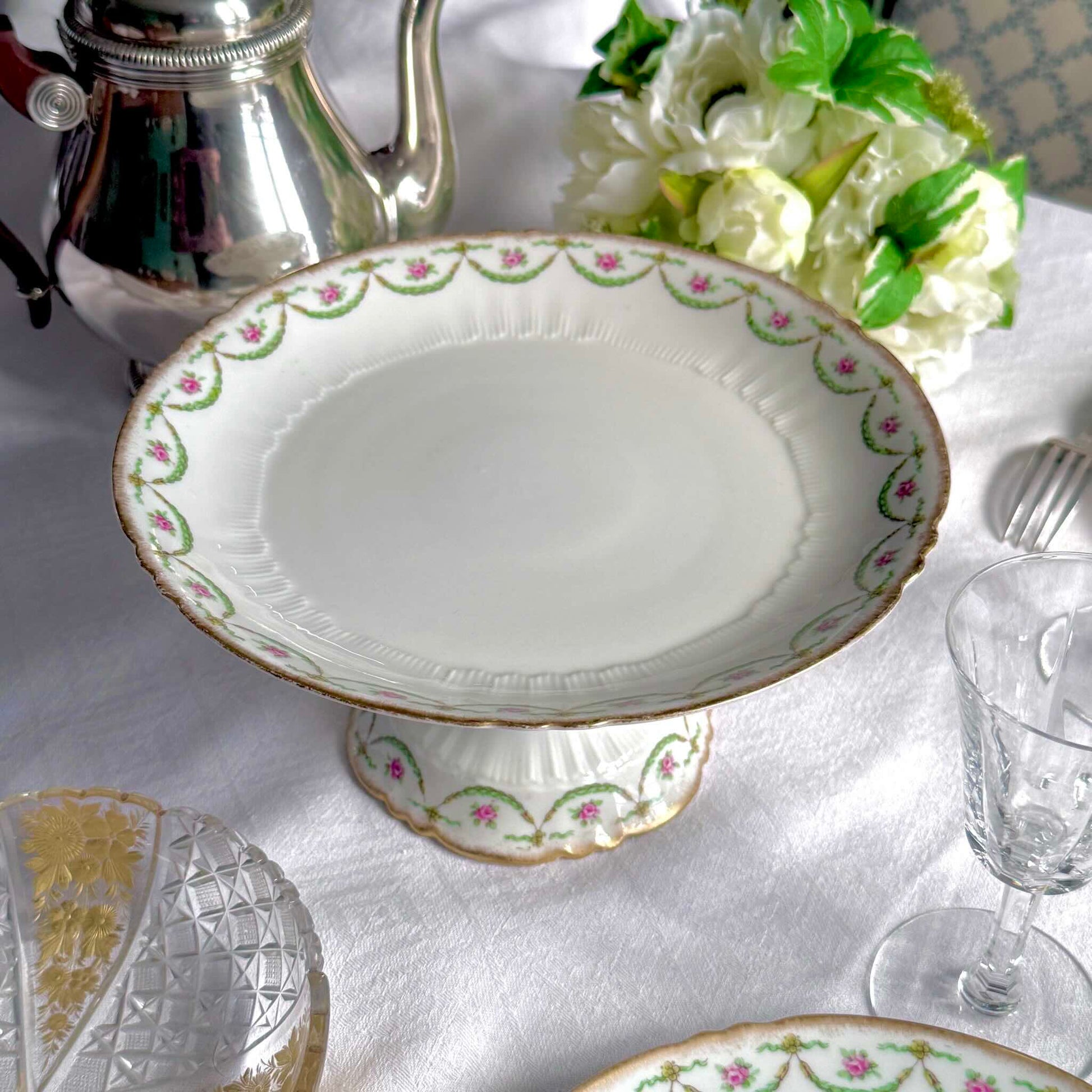 Antique Limoges porcelain compotier on pedestal, pink rose floral pattern and gold trim, late 19th or early 20th century France.