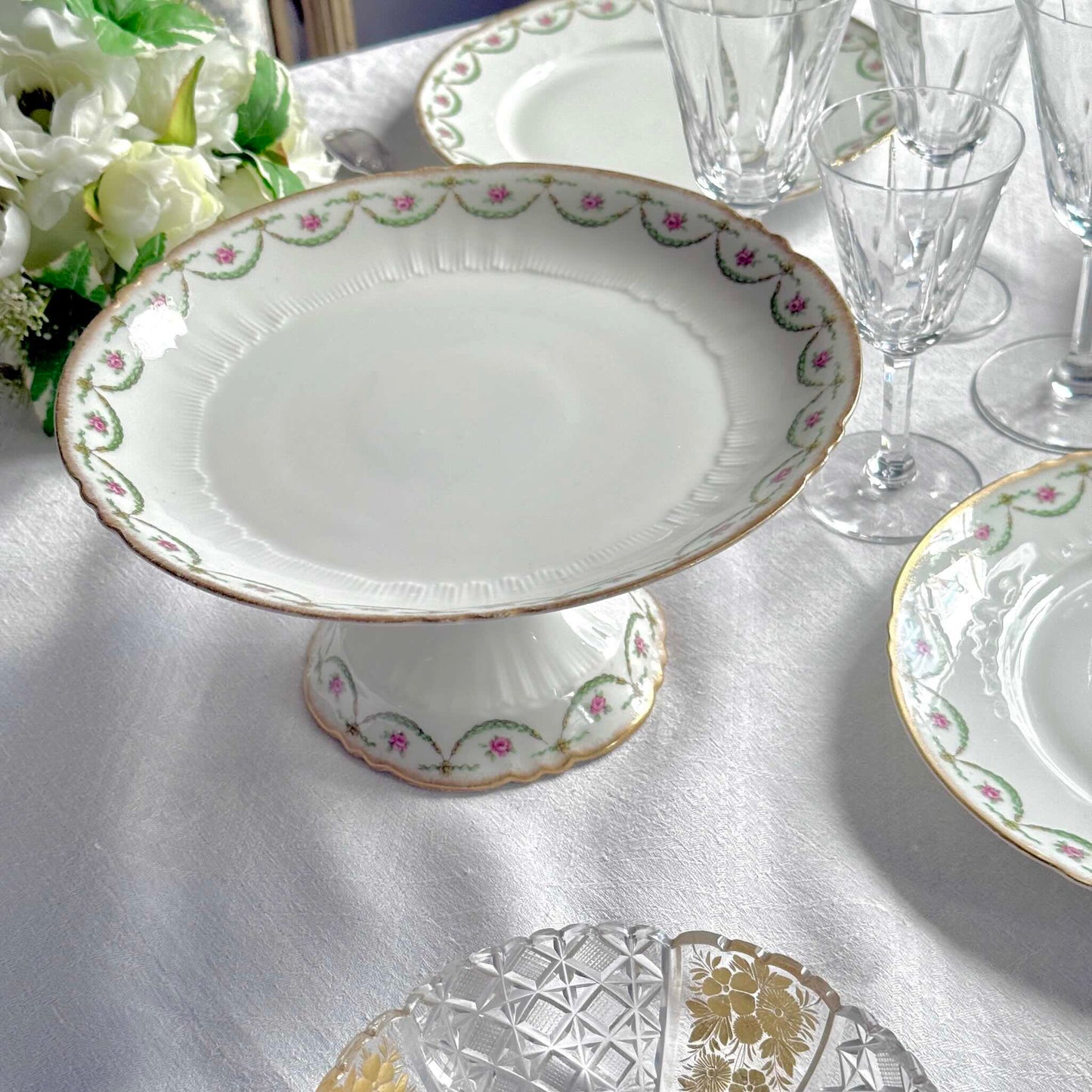 Antique Limoges porcelain compotier on pedestal, pink rose floral pattern and gold trim, late 19th or early 20th century France.