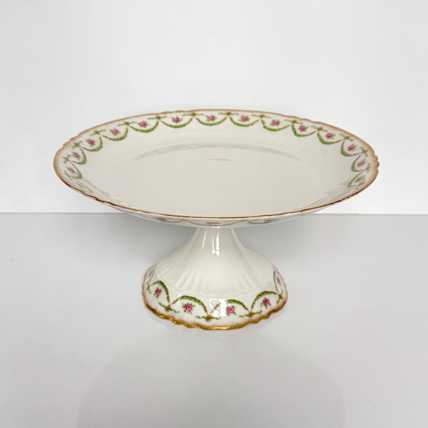 Antique Limoges porcelain compotier on pedestal, pink rose floral pattern and gold trim, late 19th or early 20th century France.