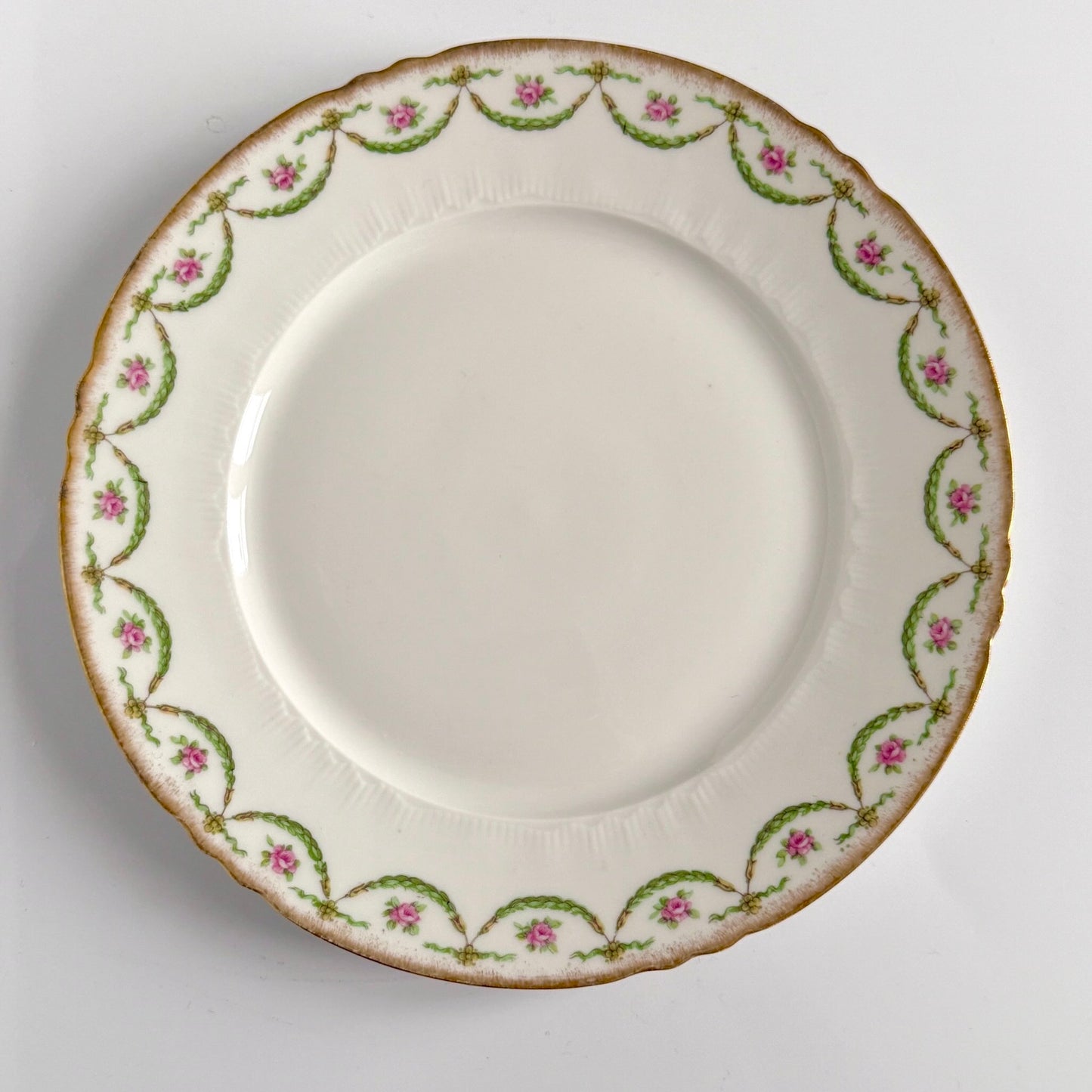 Antique Limoges porcelain dessert plate with pink rose floral pattern and gold trim, late 19th or early 20th century France.