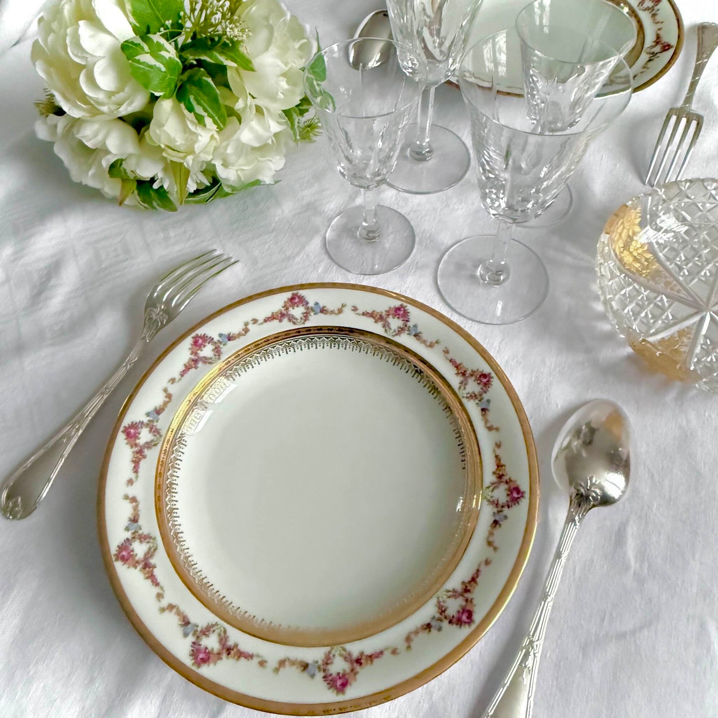 Set of two Limoges P.P. porcelain soup plates featuring floral garlands, wreaths, and rich gilding, 20th century France.