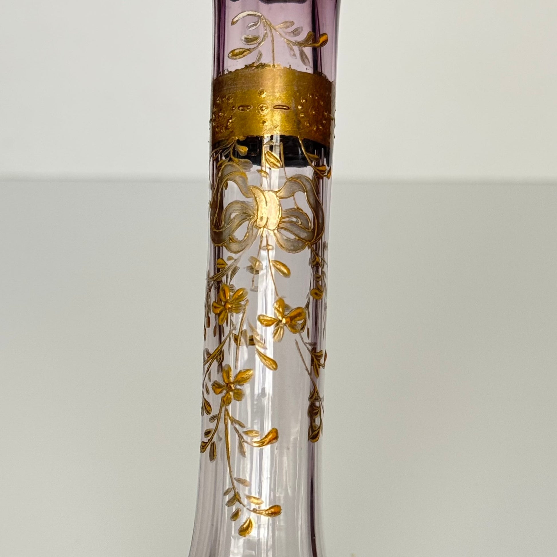 English: Antique purple-tinted glass bud vase (soliflore) with gilded ribbon and floral design, late 19th to early 20th century, French style. ; Français : Soliflore ancien en verre teinté violet avec décor doré de ruban et fleurs, fin XIXᵉ – début XXᵉ, style français. ; 日本語： 紫色のグラデーションが美しいアンティークのガラス製一輪挿し、金彩のリボンと花の装飾付き、19世紀後半〜20世紀初頭