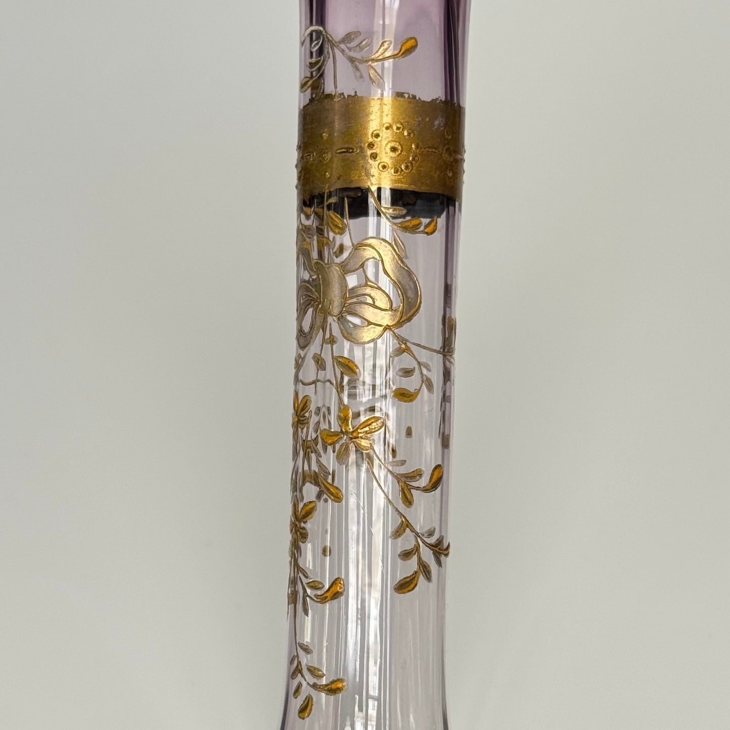 English: Antique purple-tinted glass bud vase (soliflore) with gilded ribbon and floral design, late 19th to early 20th century, French style. ; Français : Soliflore ancien en verre teinté violet avec décor doré de ruban et fleurs, fin XIXᵉ – début XXᵉ, style français. ; 日本語： 紫色のグラデーションが美しいアンティークのガラス製一輪挿し、金彩のリボンと花の装飾付き、19世紀後半〜20世紀初頭