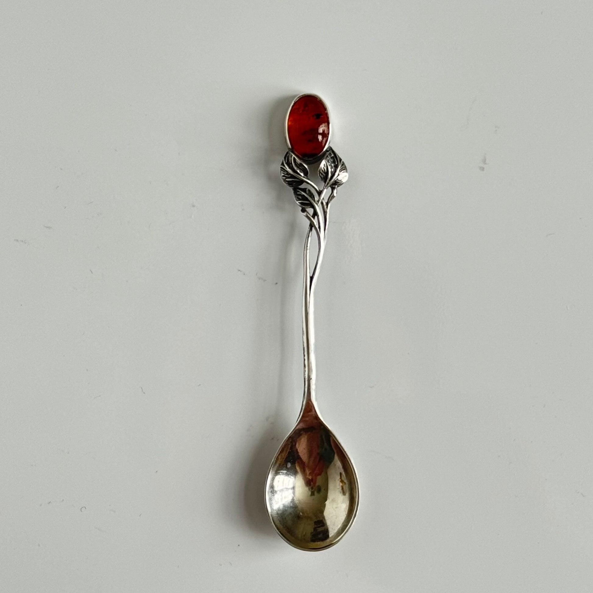 English: Art Nouveau style silver spoon with amber accent and delicate leaf motif, in 925 silver ; 日本語: アンバー（琥珀）付きアール・ヌーヴォー様式のシルバースプーン、繊細な葉モチーフと925シルバーの装飾 ; Français: Cuillère en argent style Art Nouveau avec ambre, décorée d’un motif feuillage délicat en argent 925.