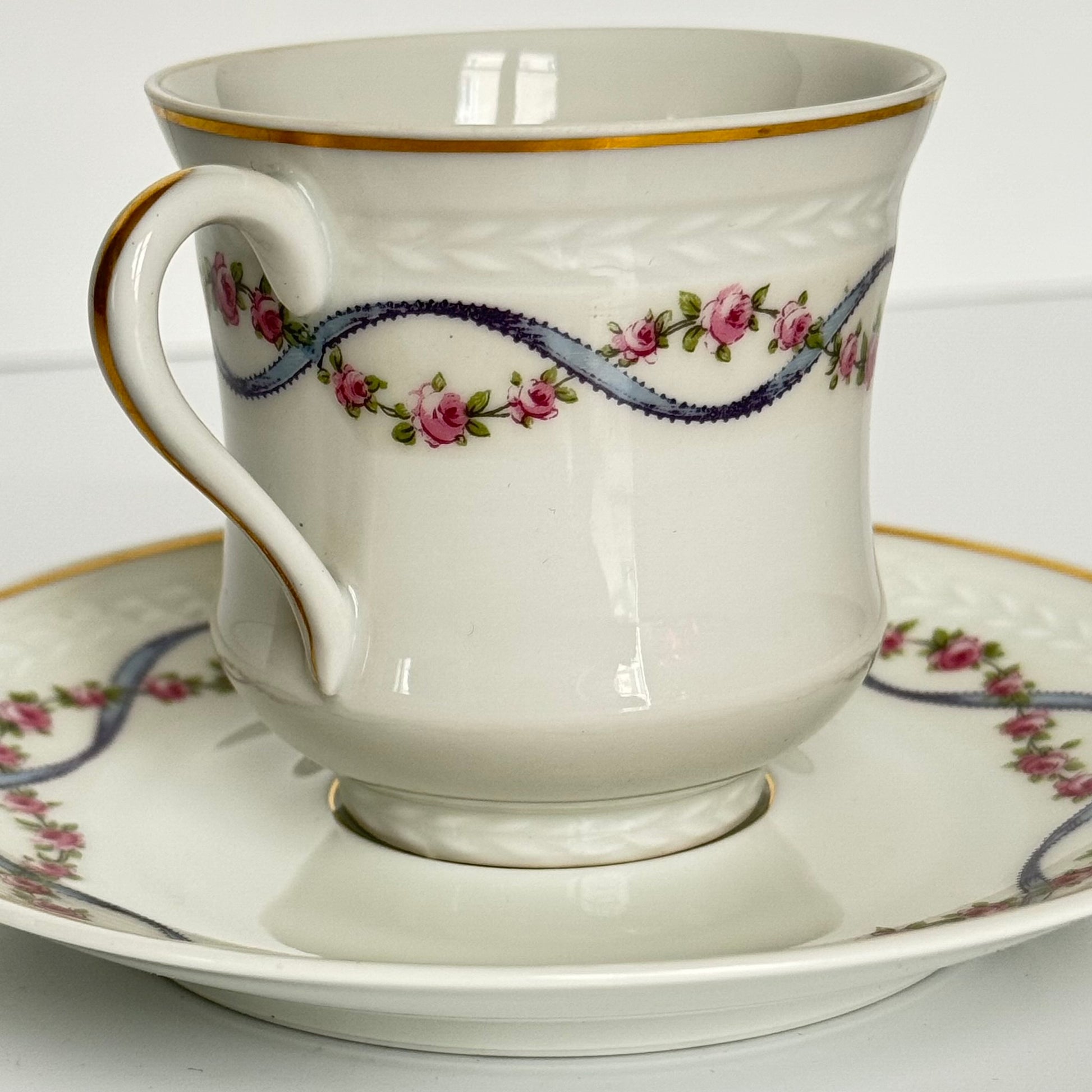 English: Bernardaud Limoges porcelain cup and saucer set, blue ribbon and rose garland design, early 20th century, signed B.H Cadeaux and B&Co; 日本語: ベルナルド・リモージュのポーセリン製カップ＆ソーサー、ブルーリボンとバラのガーランド模様、20世紀前期製造、B.H CadeauxおよびB&Coのサイン入り; Français: Ensemble tasse et soucoupe en porcelaine de Limoges par Bernardaud, décor de ruban bleu et guirlande de roses, début du XXe siècle, signé B.H Cadeaux et B&Co.