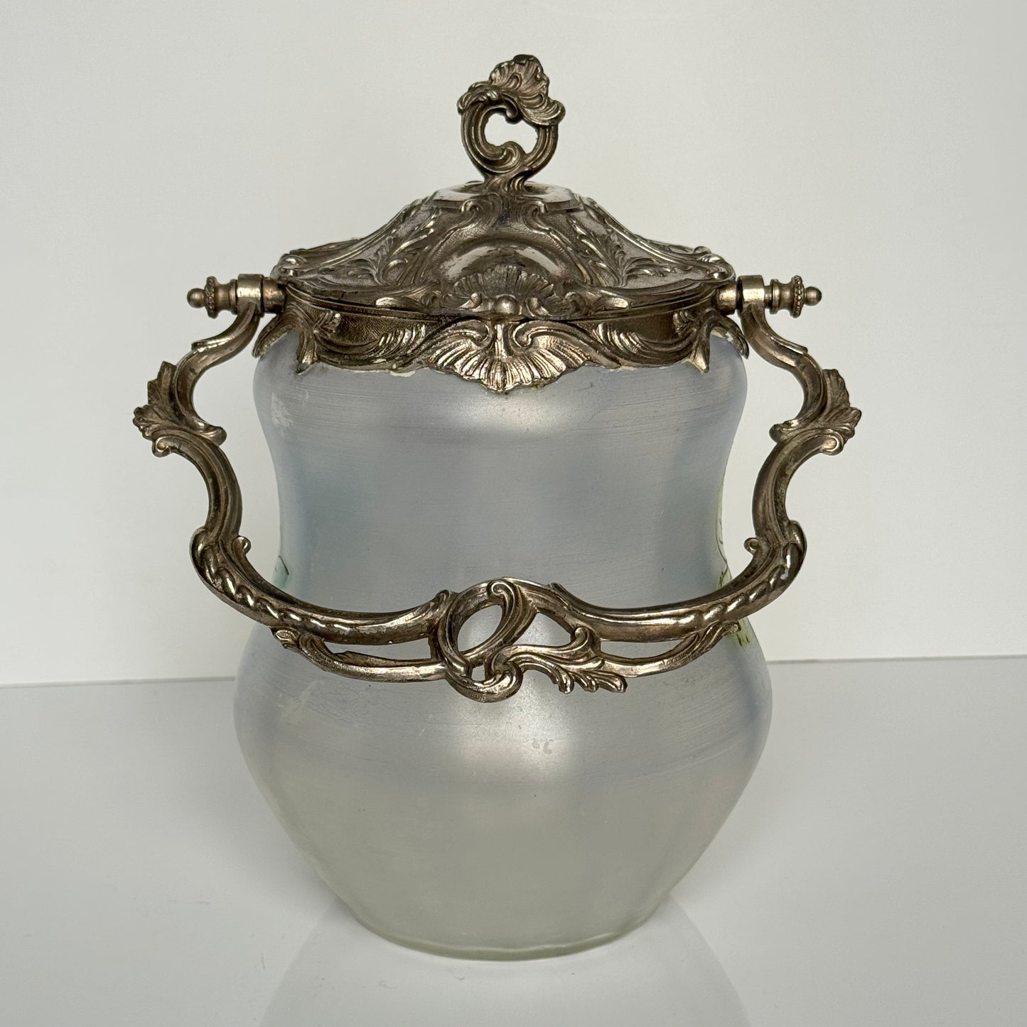English: Hand-painted glass biscuit jar from the late 19th to early 20th century, featuring floral motifs and Rocaille-style metal mounts from the Art Nouveau period; 日本語: 19世紀後期から20世紀初頭のガラス製ビスケットジャー、アール・ヌーヴォー様式のロカイユ風金属装飾と手描きの花柄入り； Français: Pot à biscuits en verre peint à la main, fin XIXᵉ – début XXᵉ siècle, décor floral et monture en métal de style rocaille de l’époque Art Nouveau.