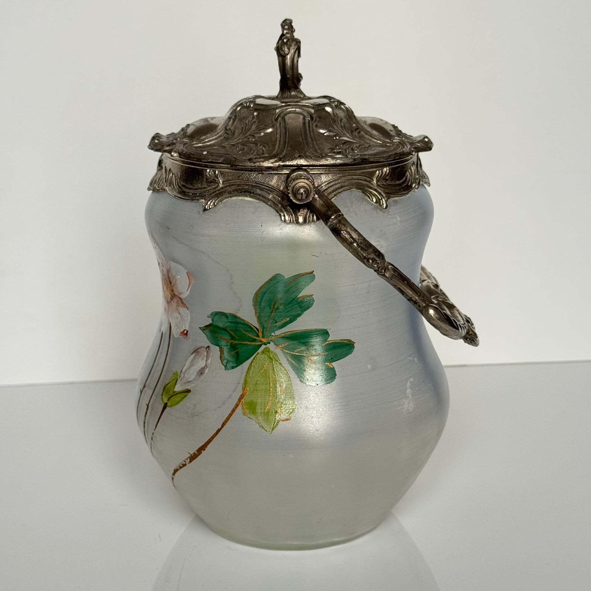 English: Hand-painted glass biscuit jar from the late 19th to early 20th century, featuring floral motifs and Rocaille-style metal mounts from the Art Nouveau period; 日本語: 19世紀後期から20世紀初頭のガラス製ビスケットジャー、アール・ヌーヴォー様式のロカイユ風金属装飾と手描きの花柄入り； Français: Pot à biscuits en verre peint à la main, fin XIXᵉ – début XXᵉ siècle, décor floral et monture en métal de style rocaille de l’époque Art Nouveau.